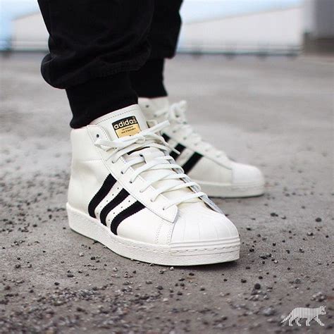 high top adidas shell toes.